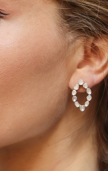 Pendiente con forma de óvalo apuntado de diamantes y plata.