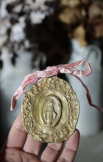 Medalla rústica de la Virgen Milagrosa en latón para cuna. Hecha artesanalmente en España por Sandra Bellew.
