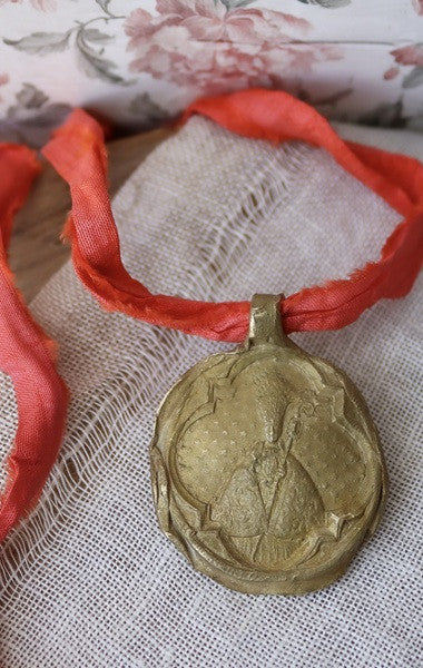 Medalla rústica de San Fermín en latón. Hecha artesanalmente por Sandra Bellew.