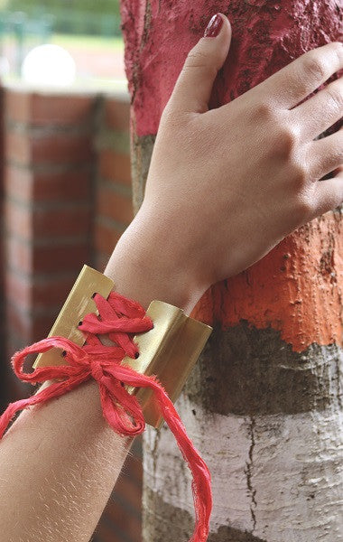 Brazalete en forma de abanico en latón con cinta de seda. Hecho artesanalmente por Sandra Bellew.