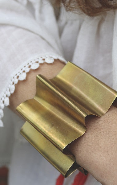 Brazalete en forma de abanico en latón con cinta de seda. Hecho artesanalmente por Sandra Bellew.