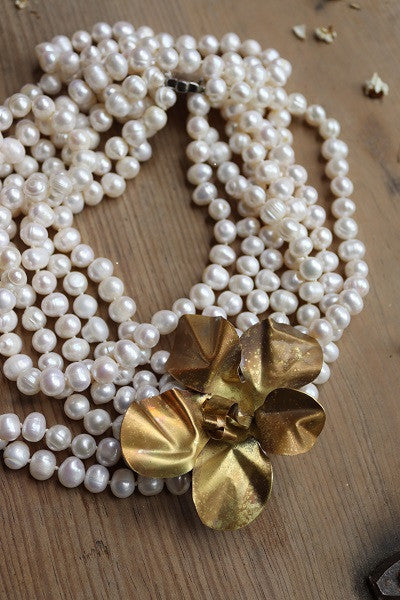Collar de perlas cultivadas con flor de latón. Hecho artesanalmente en España por Sandra Bellew.