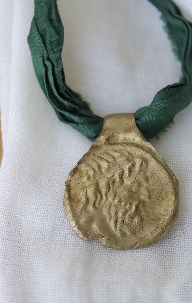 Colgante de moneda griega en latón. Hecho artesanalmente en España por Sandra Bellew.