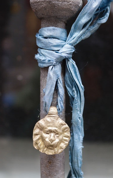 Colgante rústico de cabeza de león en latón. Hecho artesanalmente en España por Sandra Bellew.