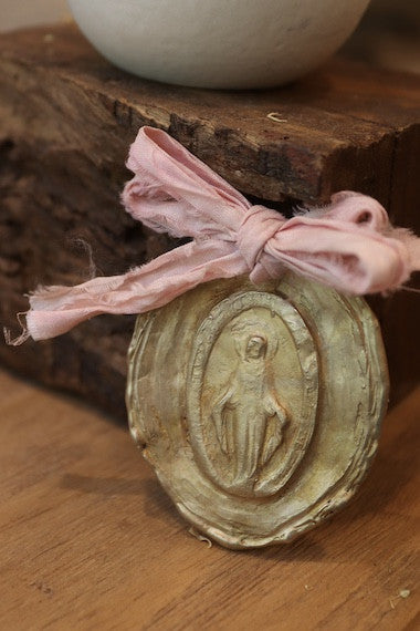 Medalla rústica de la Virgen Milagrosa en latón para carrito. Hecha artesanalmente en España por Sandra Bellew.