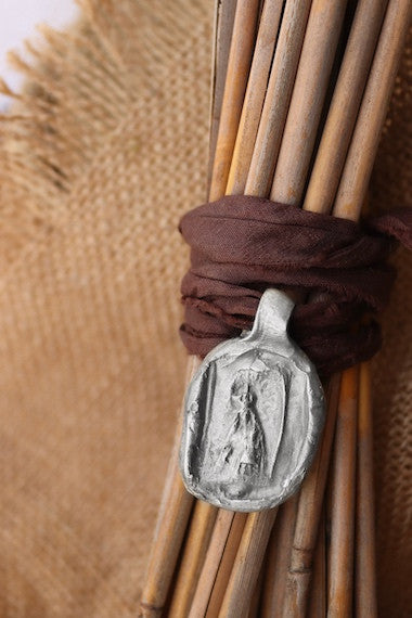 Medalla rústica de la Virgen Blanca para ramo de novia en plata. Hecha artesanalmente en España por Sandra Bellew.