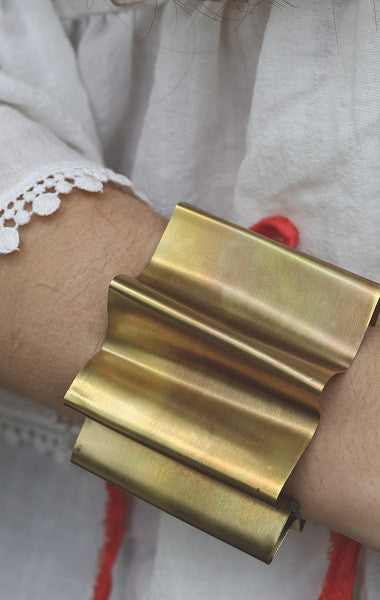 Brazalete en forma de abanico en latón con cinta de seda. Hecho artesanalmente por Sandra Bellew.
