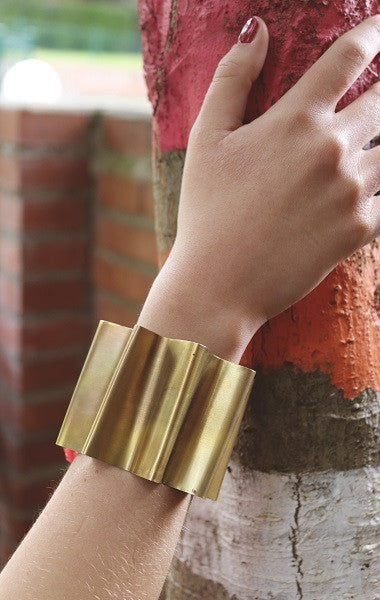 Brazalete en forma de abanico en latón con cinta de seda. Hecho artesanalmente por Sandra Bellew.