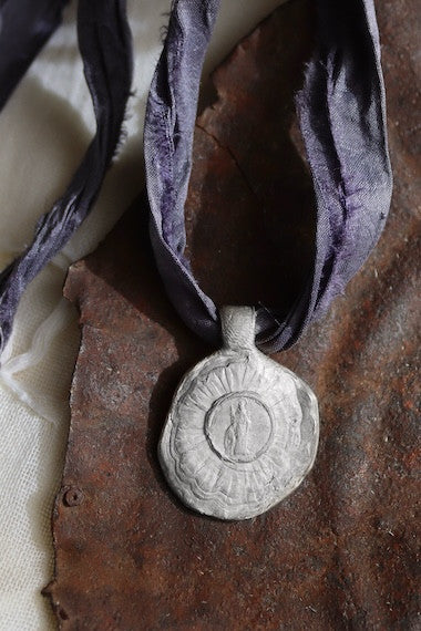 Medalla rústica de Santa Cristina en plata. Hecha artesanalmente en España por Sandra Bellew.