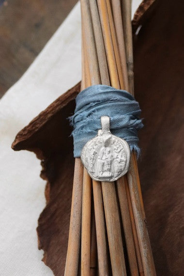 Medalla rústica de la Virgen de Nuria para ramo de novia en plata. Hecha artesanalmente en España por Sandra Bellew.