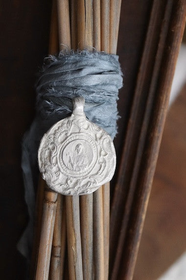 Medalla rústica de Santa Elena para ramo de novia en plata. Hecha artesanalmente en España por Sandra Bellew.