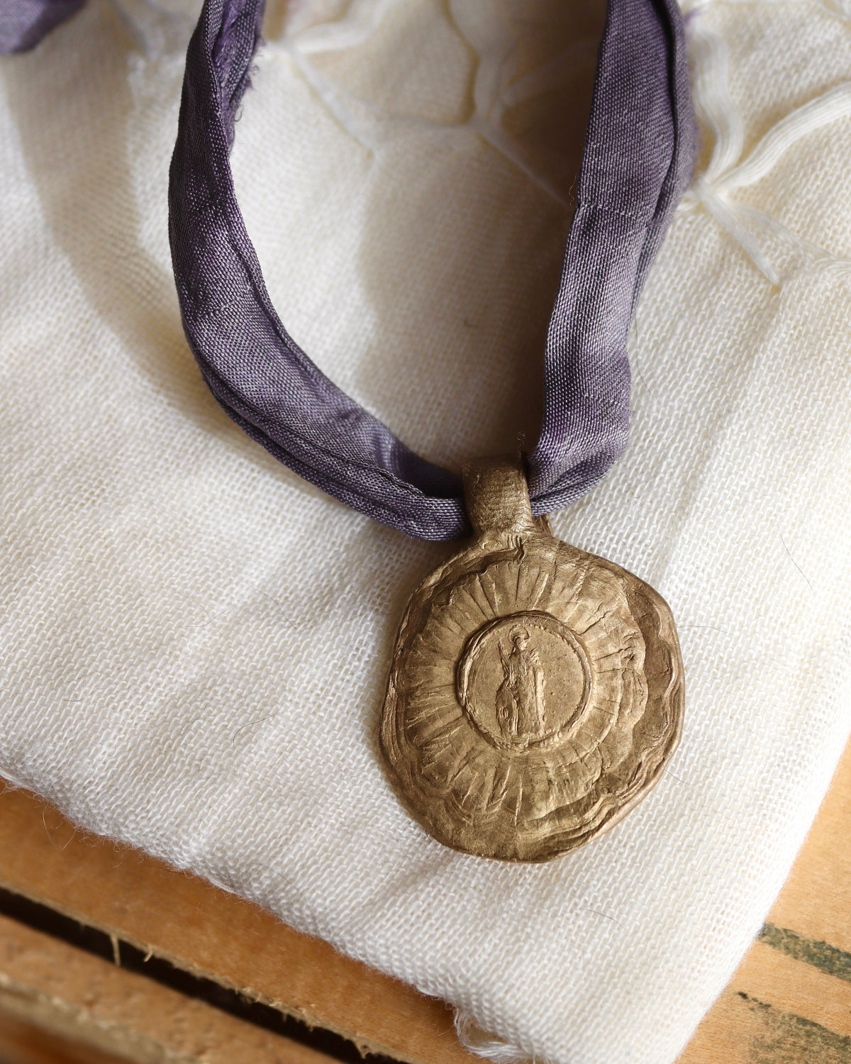 Medalla rústica de Santa Cristina en latón. Hecha artesanalmente en España por Sandra Bellew.