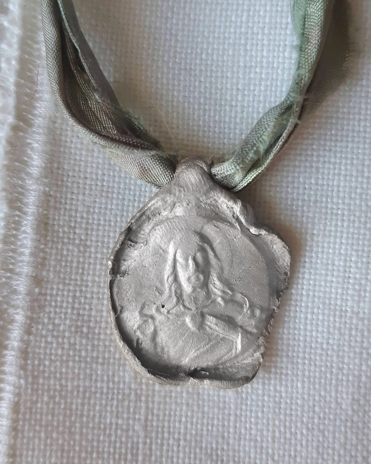 Medalla rústica del Cristo de la Misericordia en plata. Hecha artesanalmente en España por Sandra Bellew.