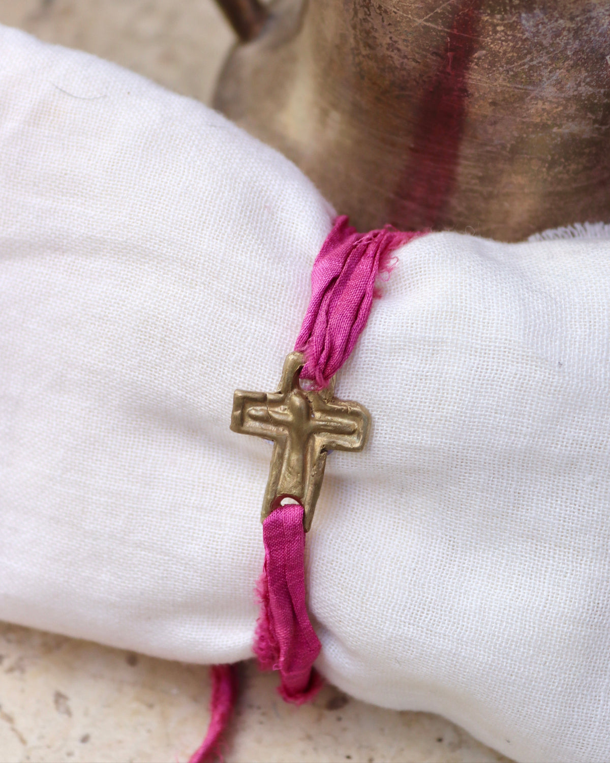 Pulsera rústica de cruz en latón y en plata. Hecha artesanalmente en España por Sandra Bellew.