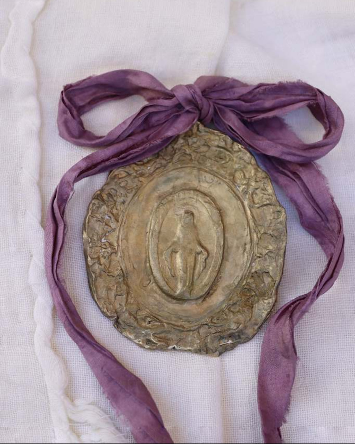 Medalla rústica de la Virgen Milagrosa en latón para cuna. Hecha artesanalmente en España por Sandra Bellew.