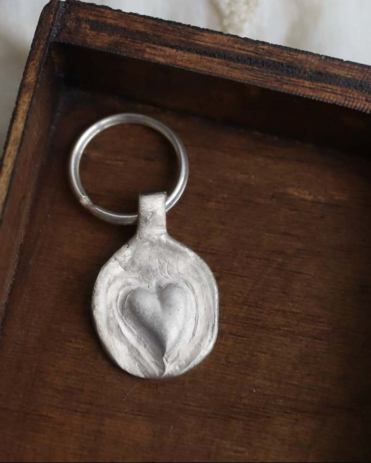 Llavero rústico con imagen de un corazón en plata. Hecho artesanalmente en España por Sandra Bellew.
