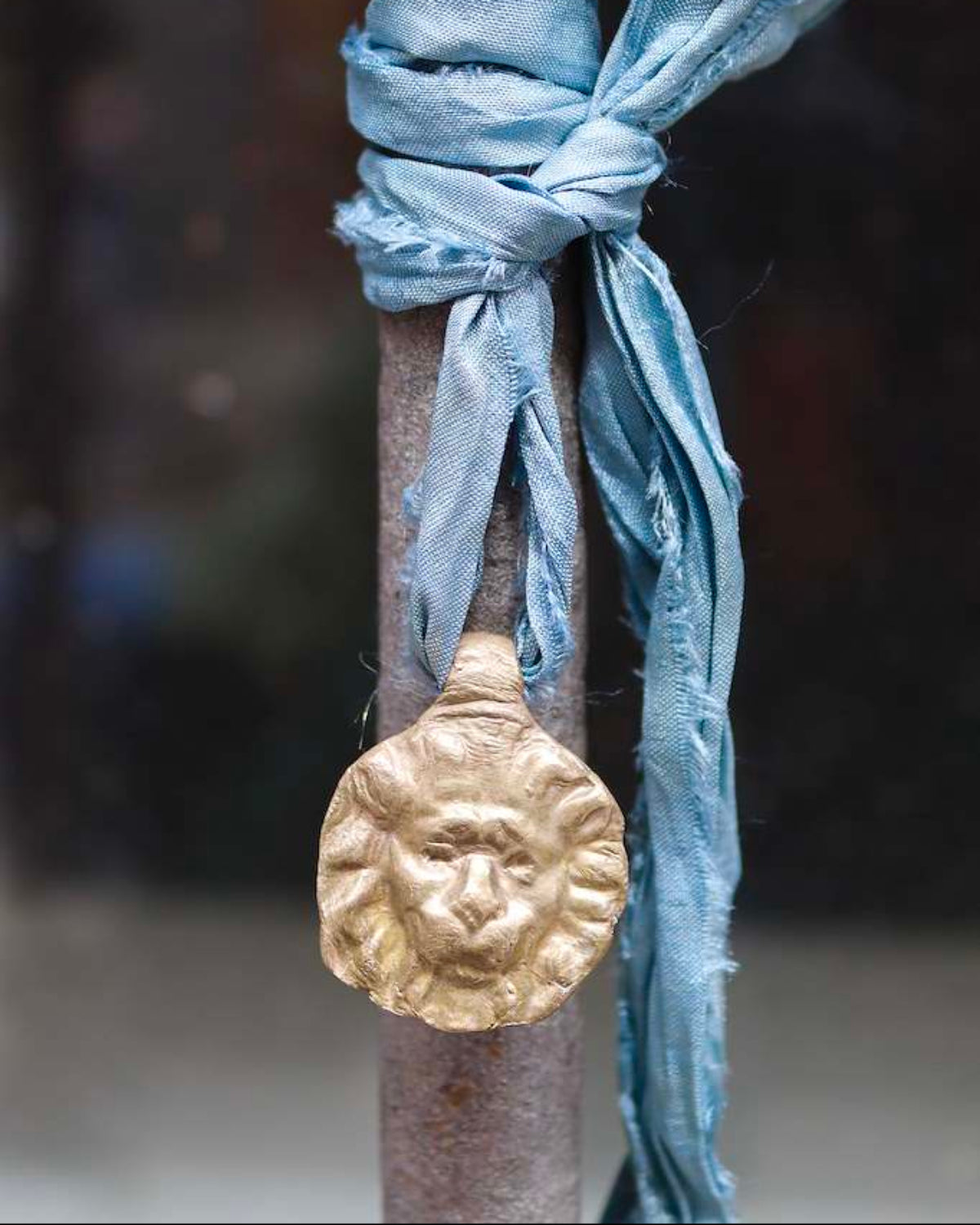 Colgante rústico de cabeza de león en latón. Hecho artesanalmente en España por Sandra Bellew.