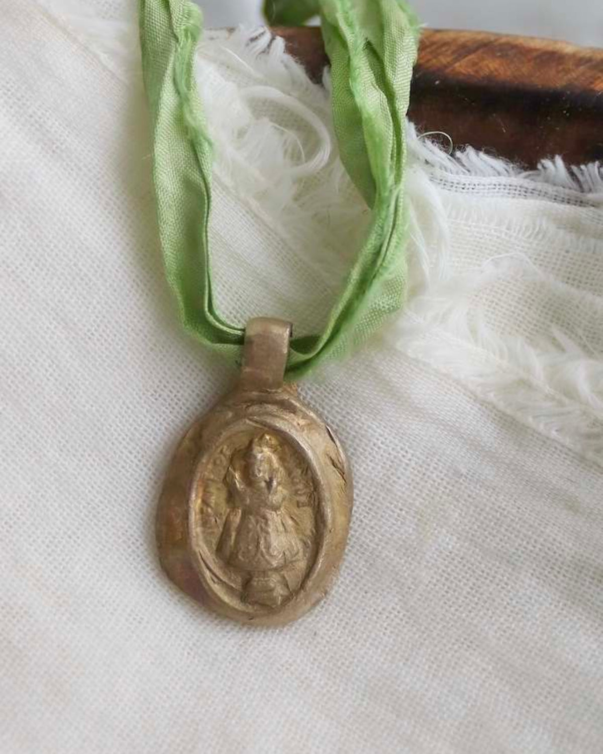Medalla rústica del Niño de Praga en latón. Hecha artesanalmente en España por Sandra Bellew.
