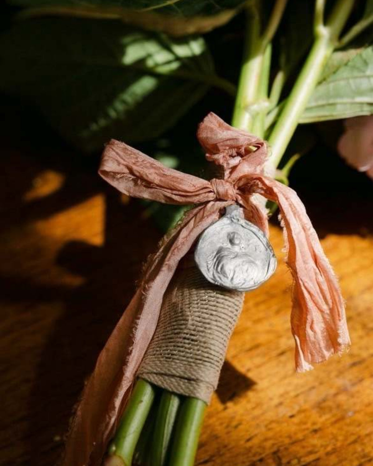 Medalla rústica de la Inmaculada Concepción para ramo en plata. Hecha artesanalmente por Sandra Bellew.