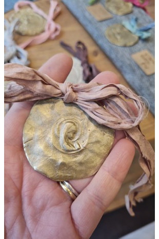 Medalla rústica de la Virgen Niña para carrito en latón. Hecha artesanalmente en España por Sandra Bellew.