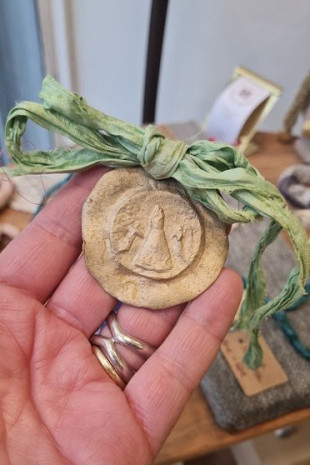 Medalla rústica  de la Virgen del Pilar para carrito de bebé en latón. Hecha artesanalmente por Sandra Bellew.