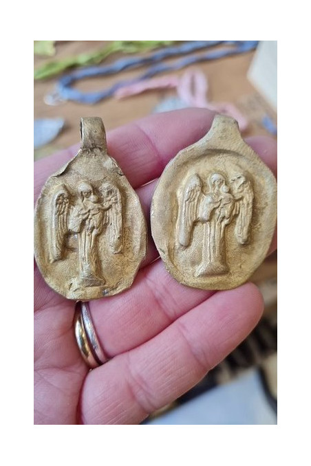Medalla rústica del Angel de la Guarda con bebé en latón. Hecha artesanalmente por Sandra Bellew.