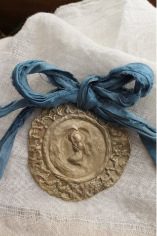 Medalla rústica del Angelito de la Guarda  para cuna en latón. Hecha artesanalmente por Sandra Bellew.