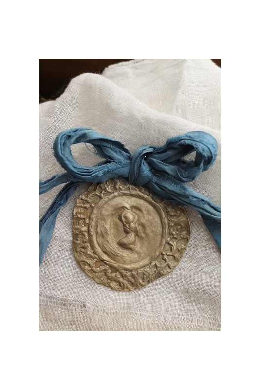 Medalla rústica del Angelito de la Guarda  para cuna en latón. Hecha artesanalmente por Sandra Bellew.