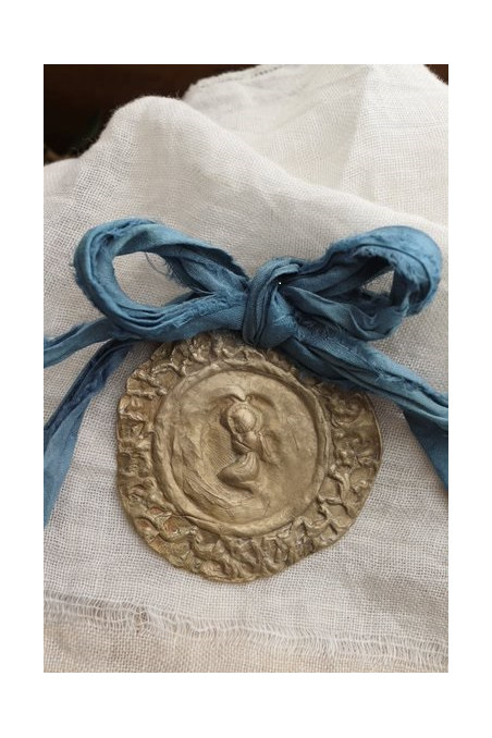 Medalla rústica del Angelito de la Guarda  para cuna en latón. Hecha artesanalmente por Sandra Bellew.