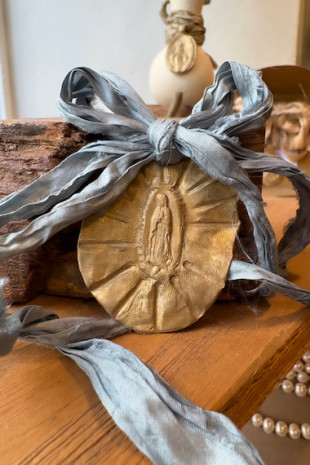 Medalla rústica de la Virgen Guadalupana para carrito en latón. Hecha artesanalmente por Sandra Bellew.