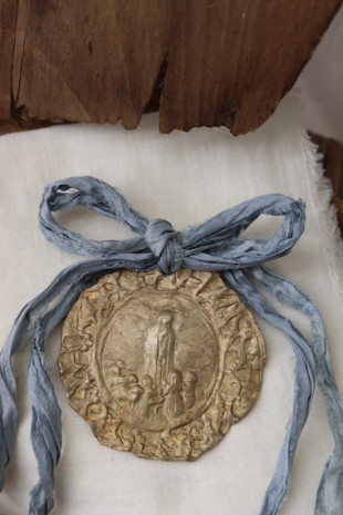 Medalla rústica de la Virgen de Fátima para cuna en latón. Hecha artesanalmente por Sandra Bellew.