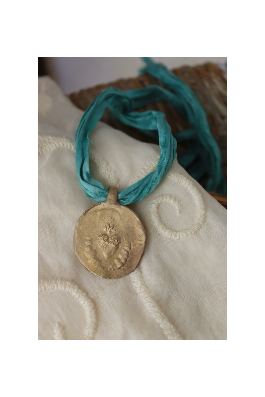 Medalla rústica del Sagrado Corazón en latón. Hecha artesanalmente por Sandra Bellew.