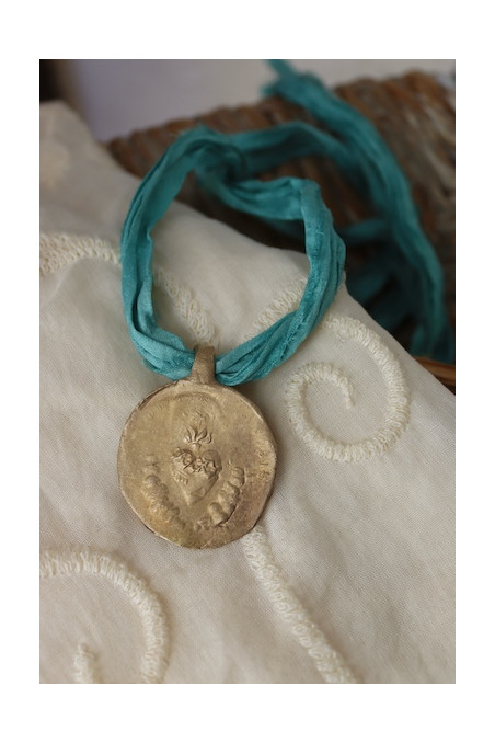 Medalla rústica del Sagrado Corazón en latón. Hecha artesanalmente por Sandra Bellew.