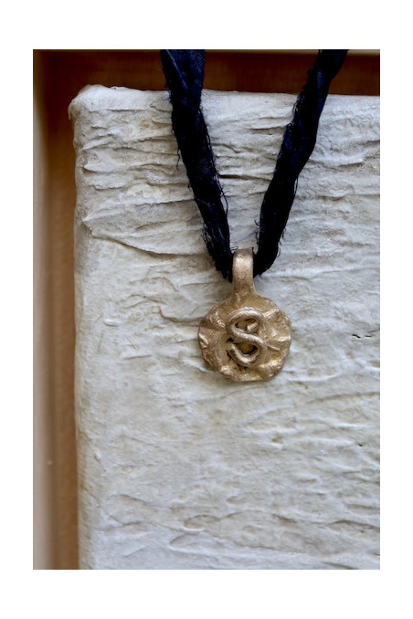 Colgante rústico con inicial en latón. Hecho artesanalmente en España por Sandra Bellew.