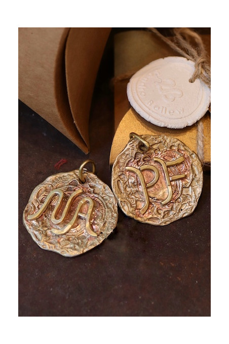 Colgante rústico con dos iniciales en latón. Hecho artesanalmente en España por Sandra Bellew.
