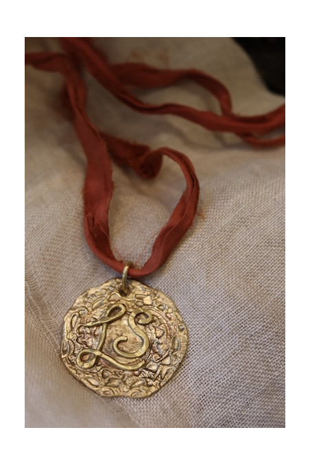 Colgante rústico con dos iniciales en latón. Hecho artesanalmente en España por Sandra Bellew.