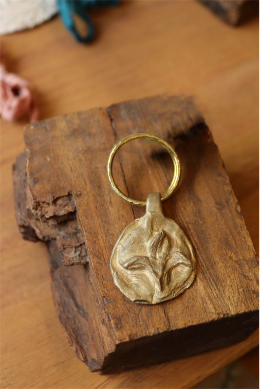 Llavero rústico con imagen de flor de lis en latón. Hecho artesanalmente en España por Sandra Bellew.