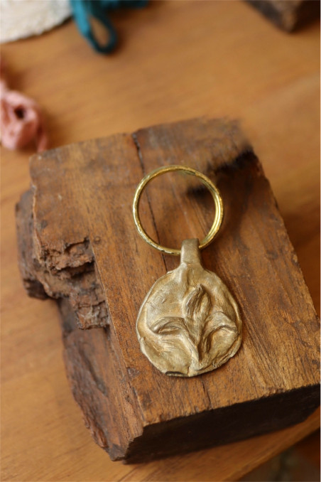 Llavero rústico con imagen de flor de lis en latón. Hecho artesanalmente en España por Sandra Bellew.