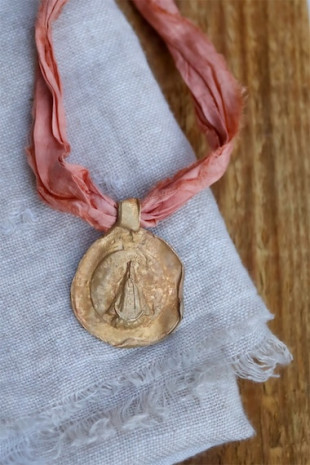 Medalla rústica de la Virgen del Juncal en latón. Hecha artesanalmente en España por Sandra Bellew.