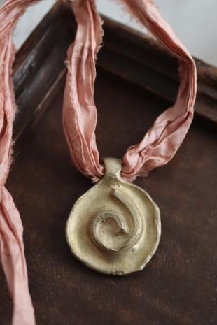 Colgante rústico de espiral celta en latón. Hecho artesanalmente en España por Sandra Bellew.