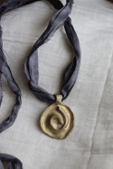 Colgante rústico de espiral celta en latón. Hecho artesanalmente en España por Sandra Bellew.