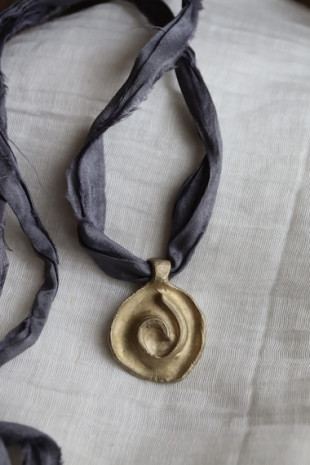 Colgante rústico de espiral celta en latón. Hecho artesanalmente en España por Sandra Bellew.