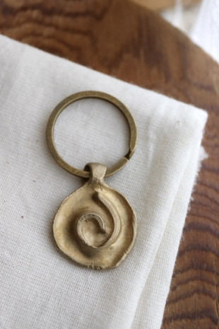 Llavero rústico con imagen de una espiral en latón. Hecho artesanalmente en España por Sandra Bellew.