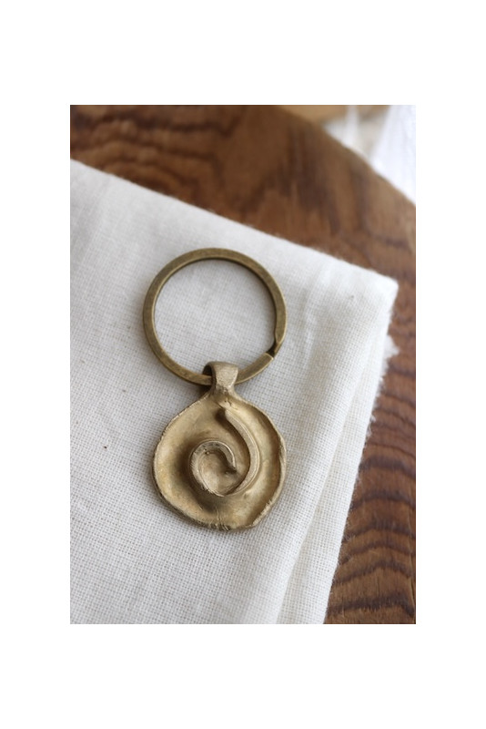 Llavero rústico con imagen de una espiral en latón. Hecho artesanalmente en España por Sandra Bellew.