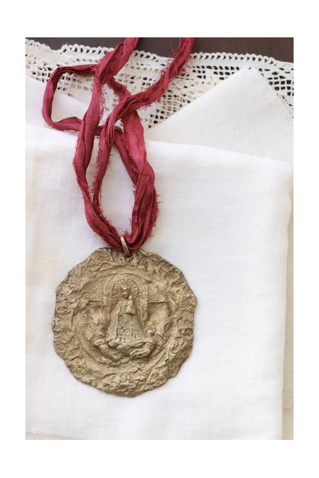 Medallón rústico de la Virgen de los Desamparados en latón. Hecha artesanalmente en España por Sandra Bellew.