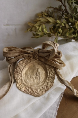 Medalla de cuna rústica de la Virgen de Montserrat en latón. Hecha artesanalmente en España por Sandra Bellew.