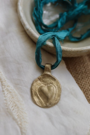 Colgante rústico de un corazón en latón. Hecho artesanalmente en España por Sandra Bellew.