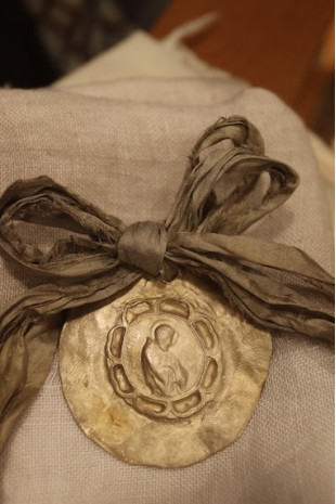 Medalla rústica de San Francisco Javier para carrito de bebé en latón. Hecha artesanalmente por Sandra Bellew.