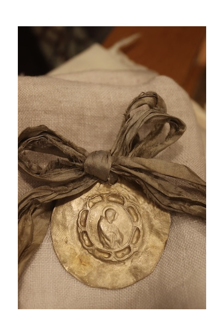 Medalla rústica de San Francisco Javier para carrito de bebé en latón. Hecha artesanalmente por Sandra Bellew.