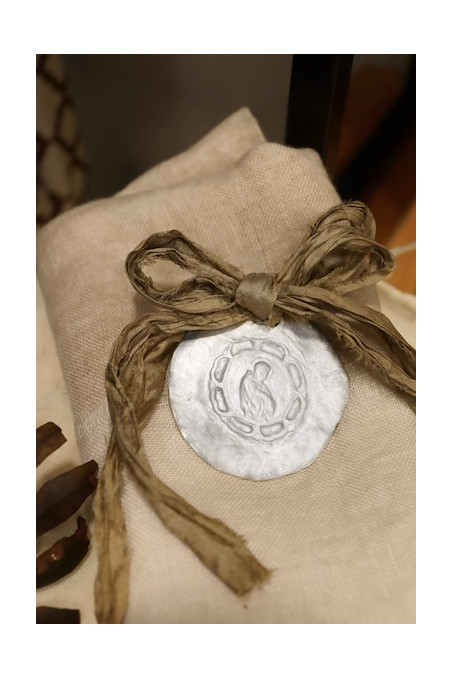 Medalla rústica de San Francisco Javier para carrito de bebé en plata. Hecha artesanalmente por Sandra Bellew.